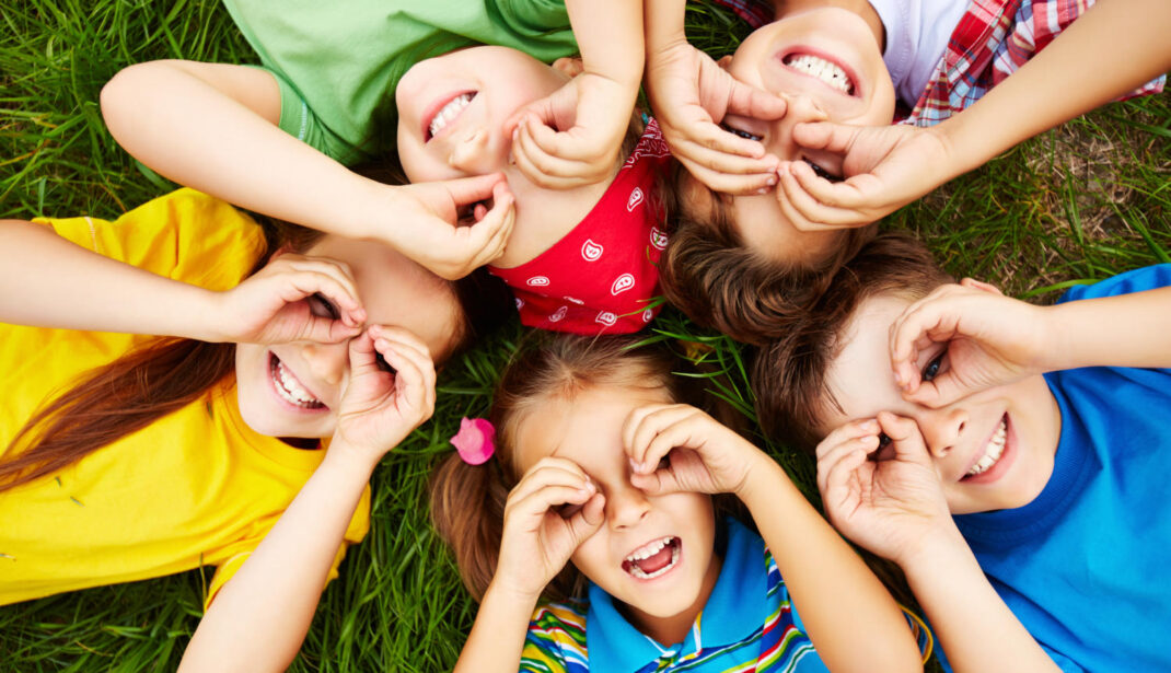 Kinder spielen auf dem Rasen