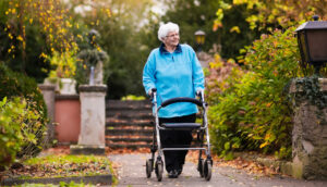 Ältere Dame mit Rollator wartet auf SBS-Senioren-Fahrdienst