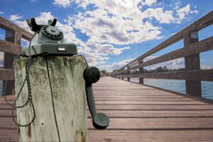 telefon auf holzpflock am steg aufs meer